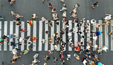 People using a cross walk, busy street 