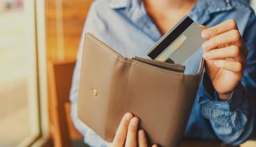 Woman pulling a payment card out of her wallet 